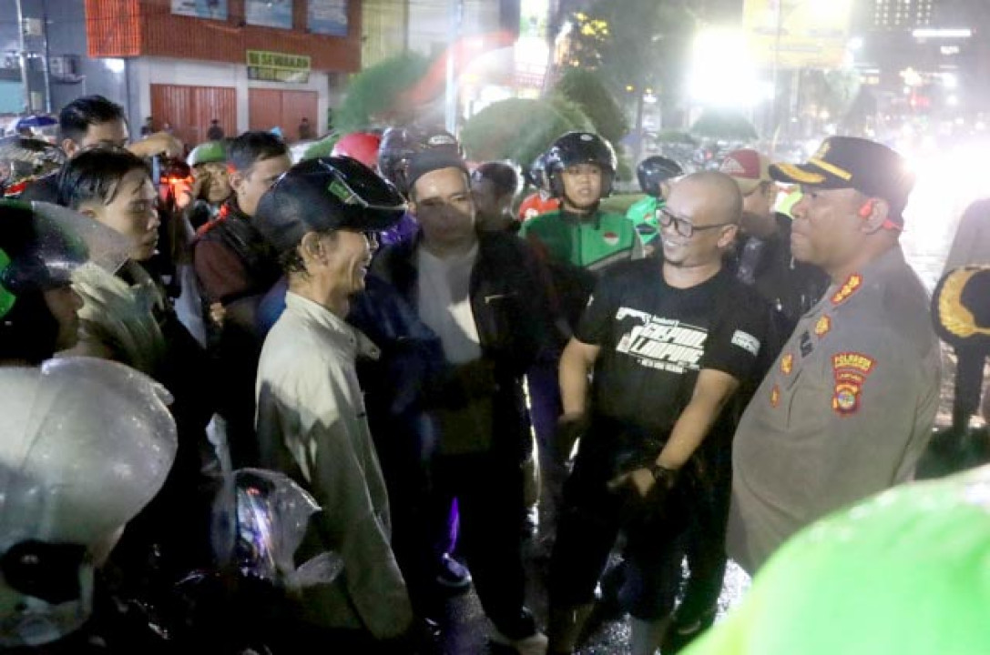 Diguyur Hujan, Polresta Bandarlampung dan Ojol Gelar Doa Bersama untuk Affan di Tugu Adipura